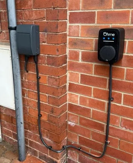 Ohme EV charger installed on brick wall