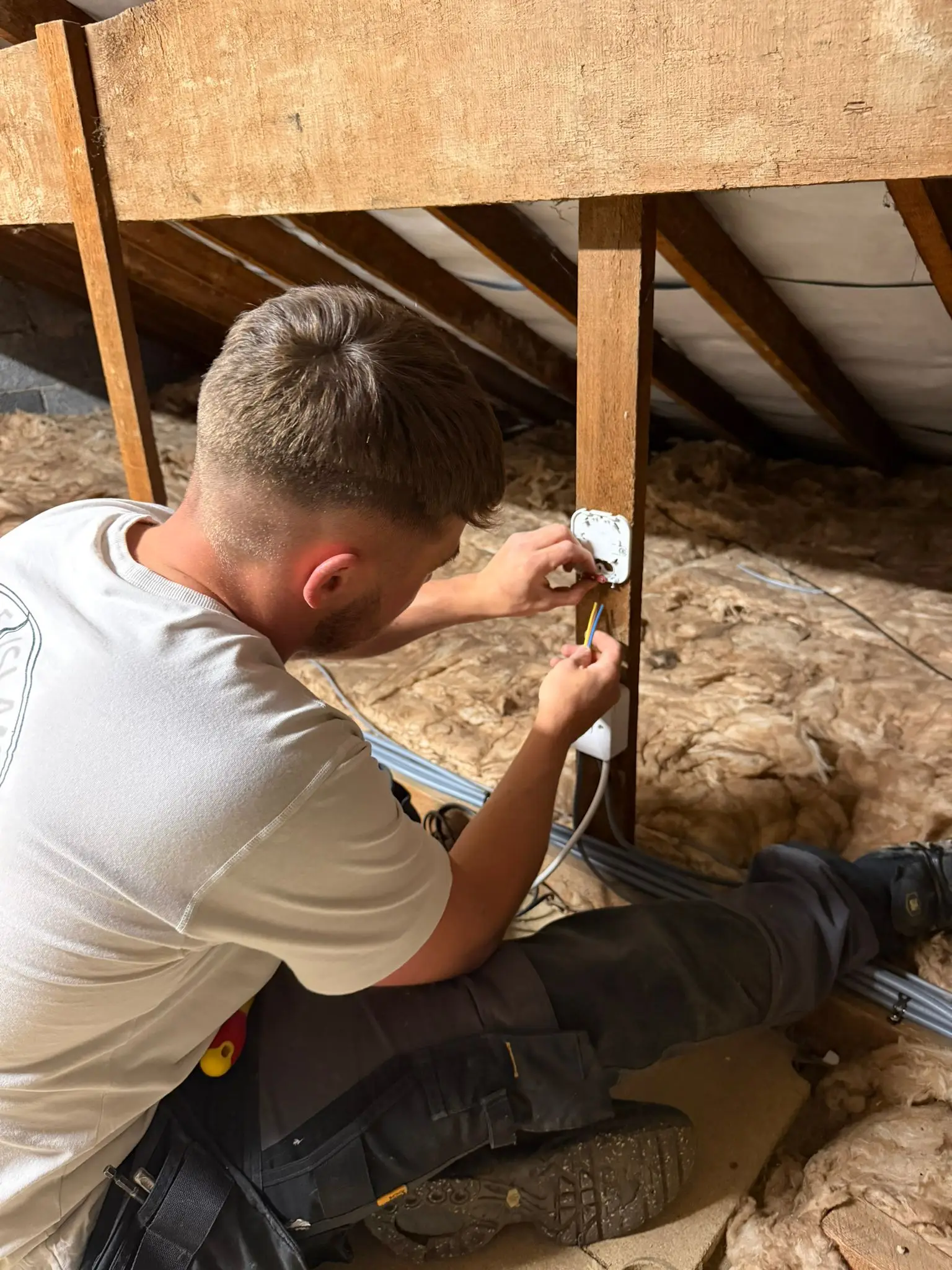 Electrician running cables in loft during rewire